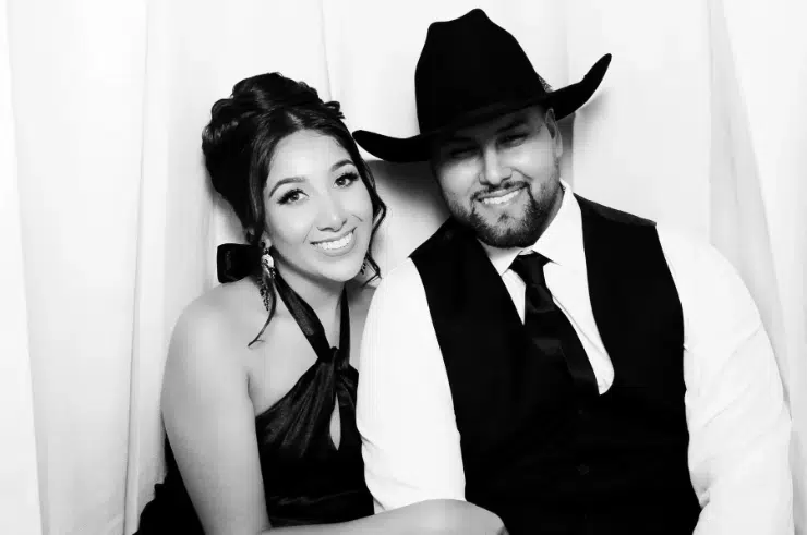 Glam photo booth at Fresno wedding party with white backdrop.