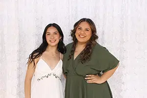 Happy client open air photo booth at birthday party with white sequin backdrop.