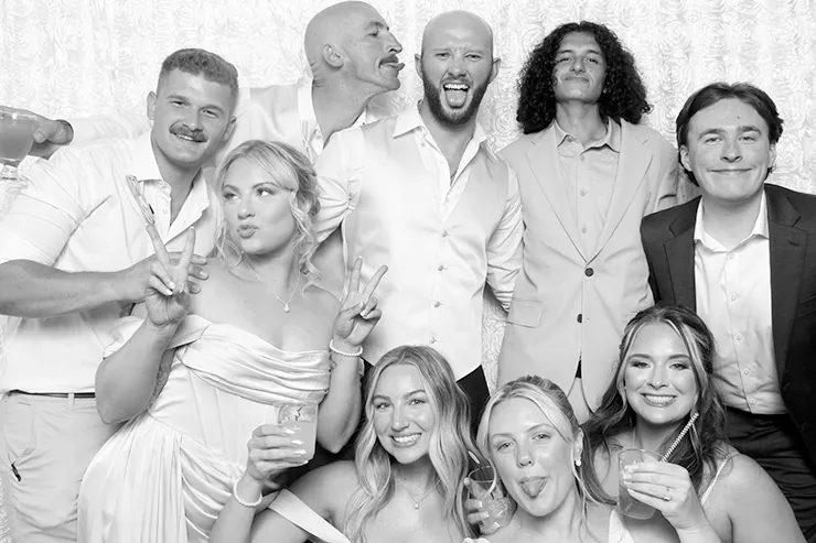 Open air photo booth at Fresno wedding with white rosette backdrop.