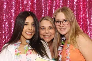 Happy client open air photo booth at Fresno CA private party with fuchsia sequin backdrop